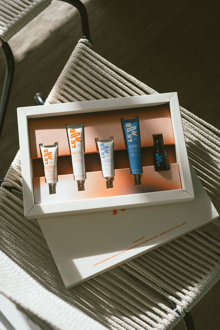 Set of skincare products in a box on a textured surface